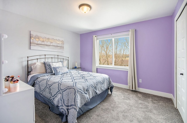 carpeted bedroom featuring a closet and baseboards