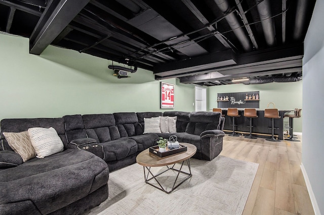 living room with indoor bar, wood finished floors, and baseboards