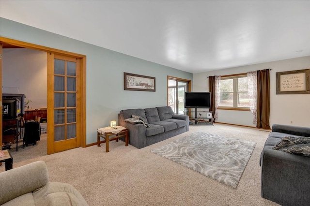 living area featuring french doors, carpet flooring, and baseboards