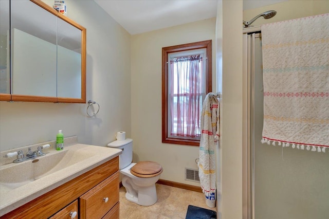 bathroom with toilet, vanity, visible vents, baseboards, and a shower stall