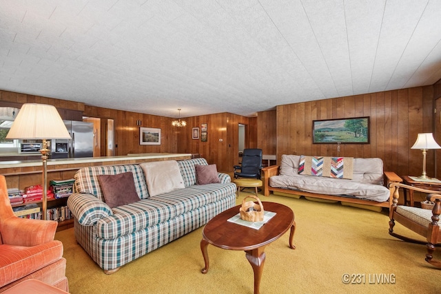 carpeted living area with a textured ceiling and a notable chandelier