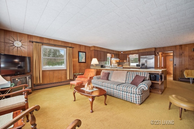 living area featuring light carpet, wood walls, and baseboard heating