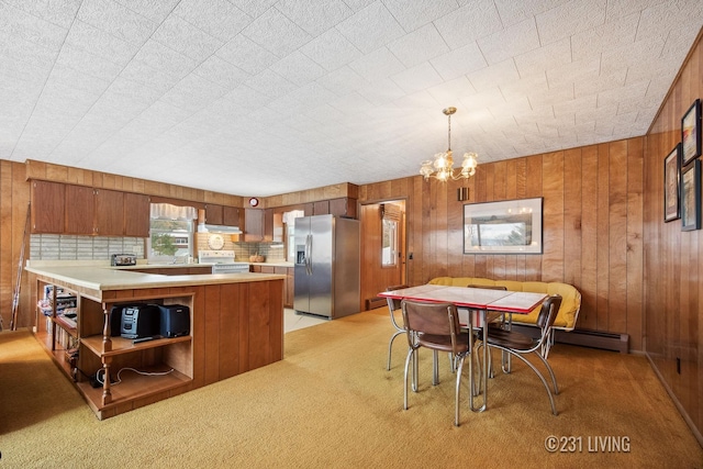 kitchen with wooden walls, light countertops, white range with electric stovetop, brown cabinetry, and stainless steel fridge