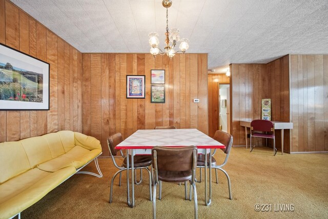 carpeted dining space with wood walls and a notable chandelier