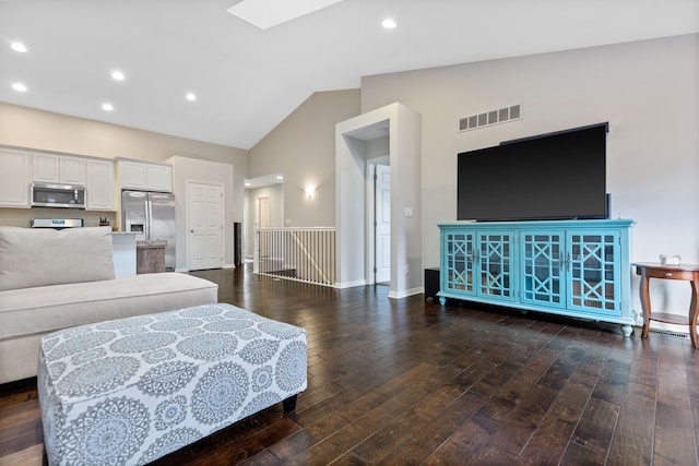 living area featuring hardwood / wood-style floors, visible vents, baseboards, recessed lighting, and lofted ceiling with skylight