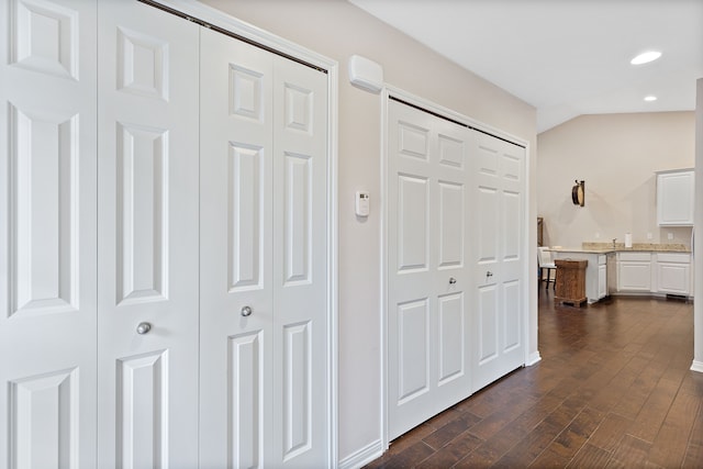 hallway with vaulted ceiling, recessed lighting, and dark wood-style flooring