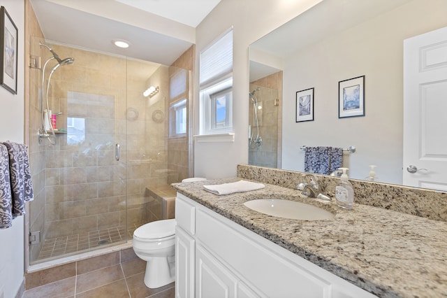 bathroom with tile patterned flooring, a shower stall, toilet, and vanity