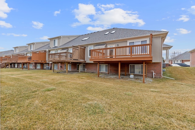 back of house with a deck, a yard, brick siding, and a residential view