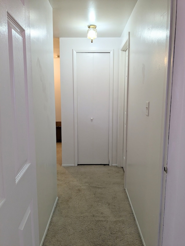 corridor with light colored carpet and baseboards