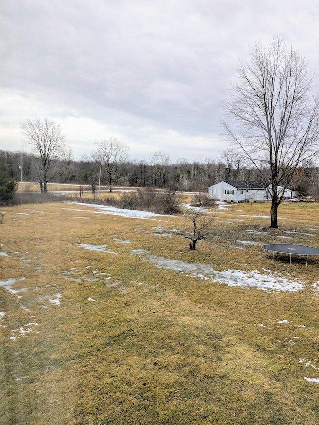 view of yard featuring a rural view and a trampoline