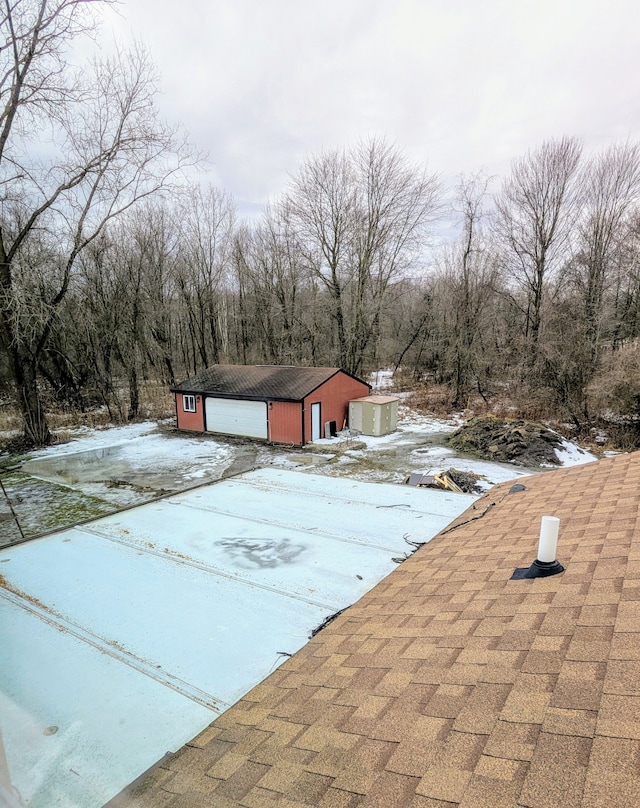 view of front of house with an outbuilding, roof with shingles, and a garage