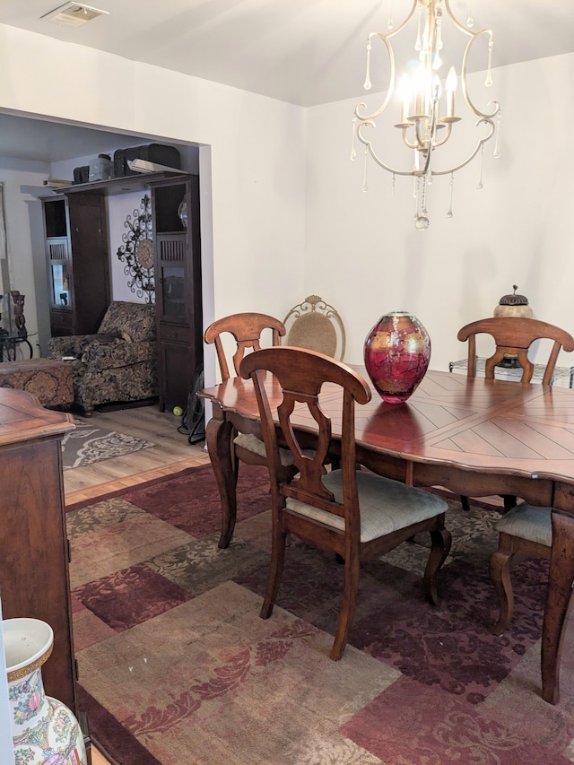 dining area with a chandelier and light wood-style flooring