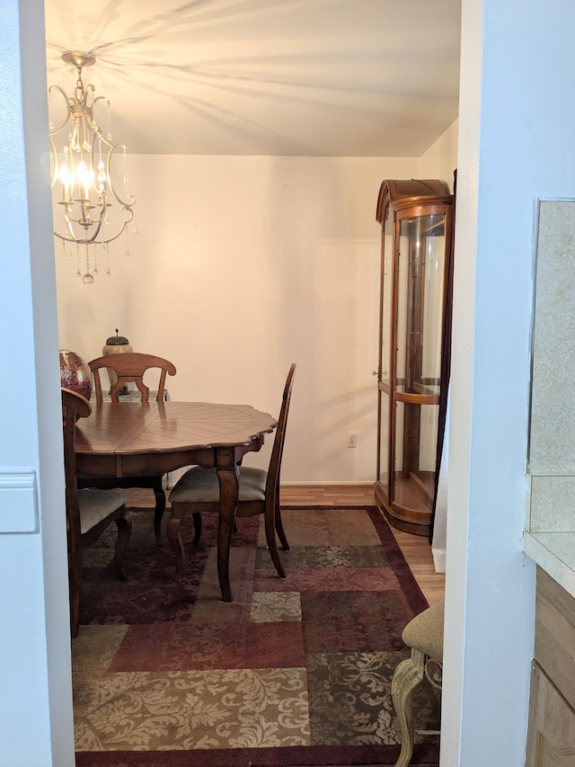 dining room with an inviting chandelier, baseboards, and wood finished floors