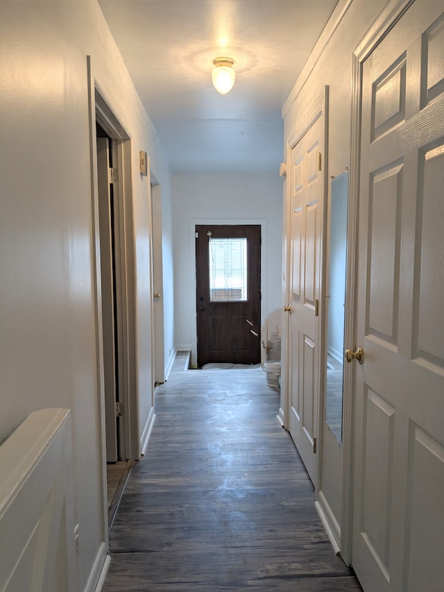 corridor with dark wood-style floors and baseboards