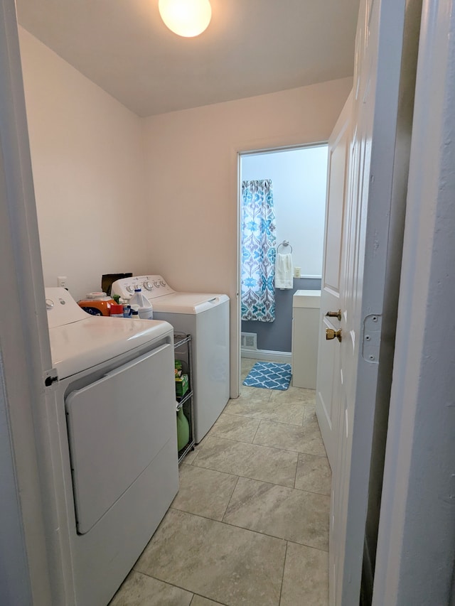 laundry area with laundry area, washing machine and dryer, light tile patterned floors, and visible vents