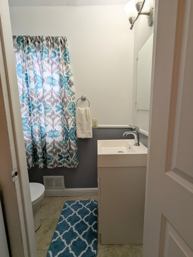 bathroom with toilet, tile patterned floors, visible vents, and vanity