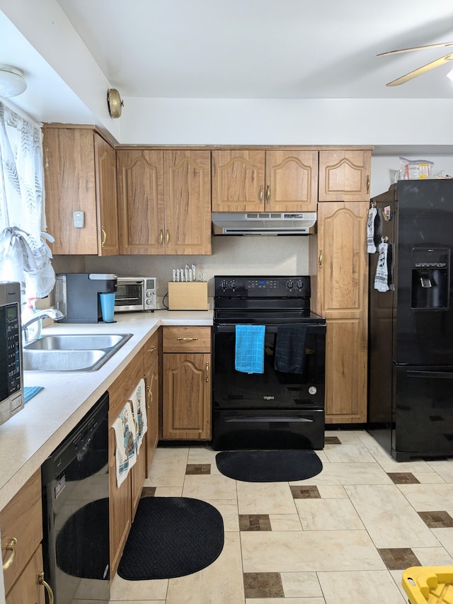 kitchen with a toaster, under cabinet range hood, a sink, light countertops, and black appliances