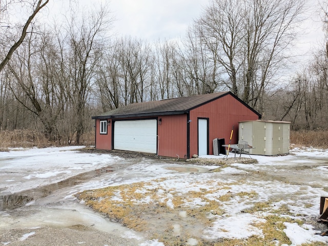 snow covered garage featuring a garage