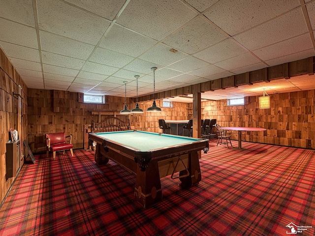 playroom featuring a drop ceiling and wooden walls