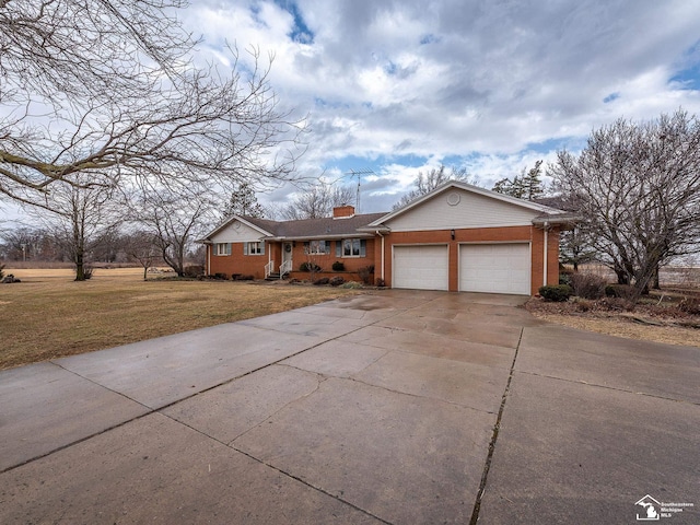 ranch-style house with brick siding, a chimney, concrete driveway, an attached garage, and a front yard