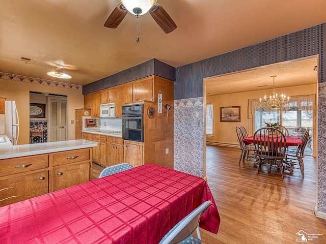 bedroom featuring visible vents, freestanding refrigerator, wallpapered walls, light wood finished floors, and an inviting chandelier