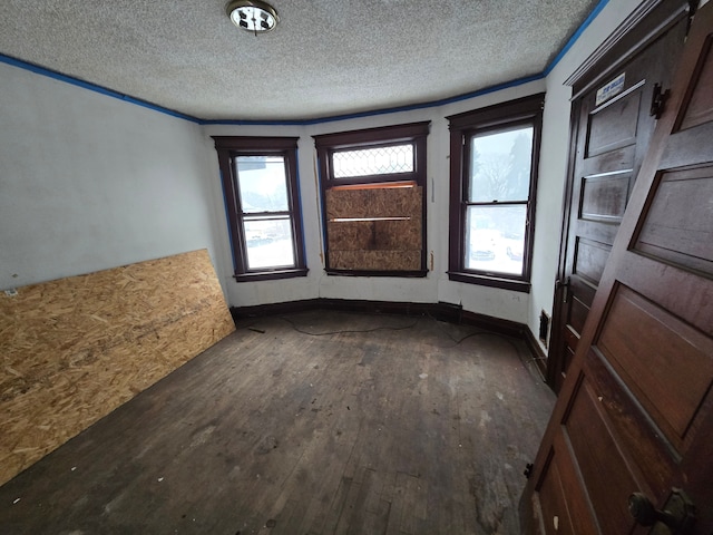 spare room with wood-type flooring, baseboards, and a textured ceiling