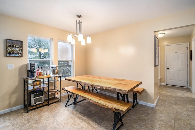 dining area featuring a notable chandelier and baseboards