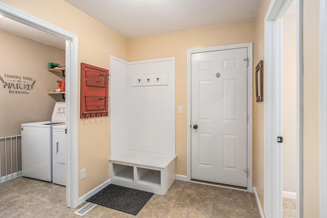 mudroom with visible vents, baseboards, and separate washer and dryer