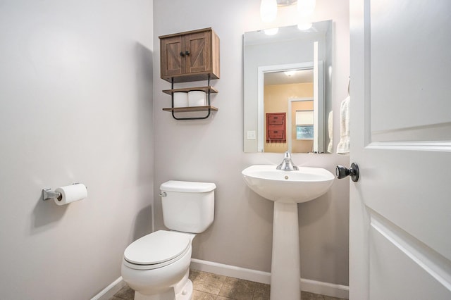 bathroom featuring baseboards and toilet