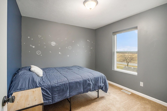 bedroom featuring baseboards, visible vents, and light colored carpet