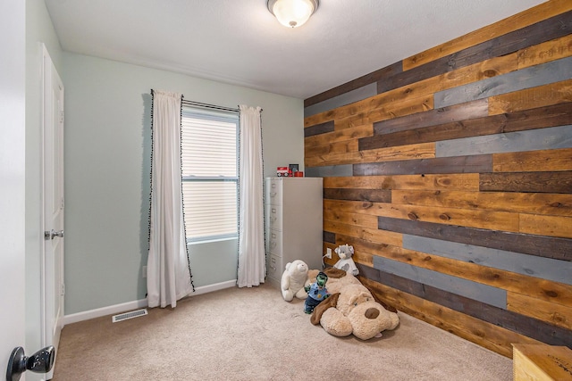 recreation room with wood walls, baseboards, visible vents, and carpet flooring