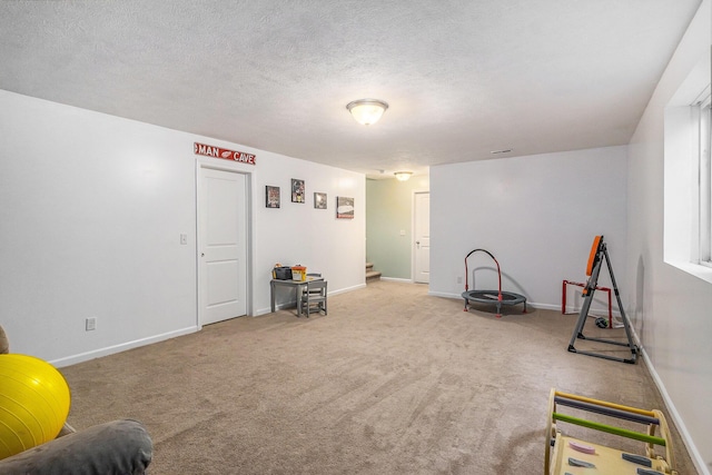 sitting room with a textured ceiling, carpet flooring, visible vents, baseboards, and stairway