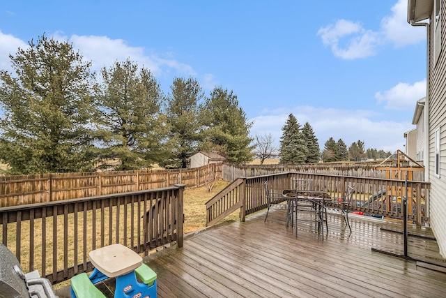 wooden deck featuring outdoor dining area and a fenced backyard