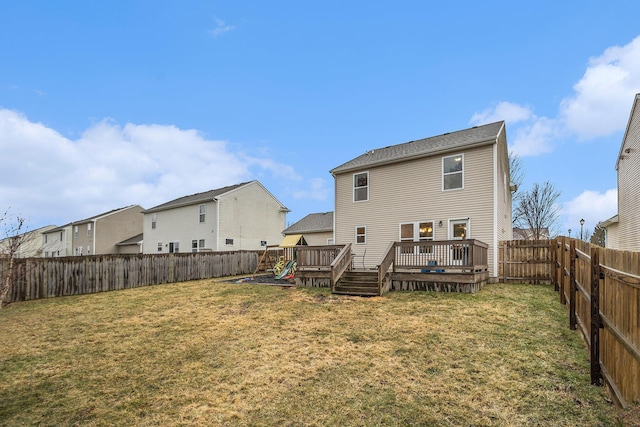 rear view of house featuring a fenced backyard, a lawn, and a wooden deck