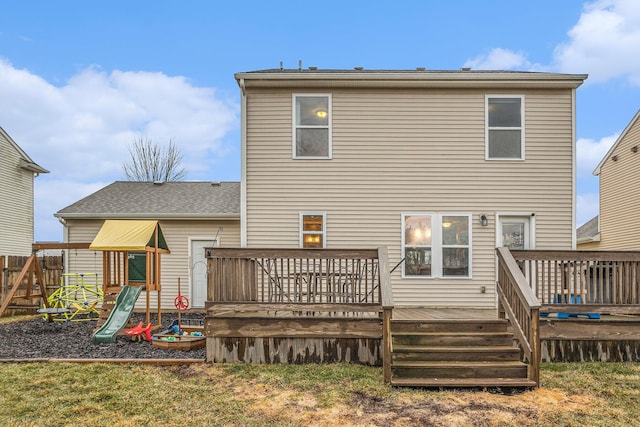 rear view of house featuring a yard, a playground, fence, and a wooden deck