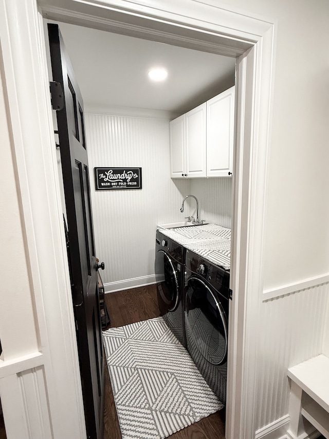 laundry area with cabinet space, dark wood-style floors, washer and dryer, and a sink