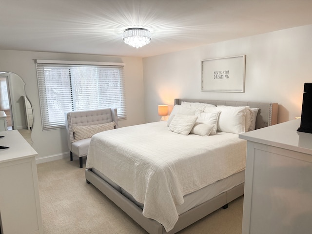 bedroom with baseboards and light carpet