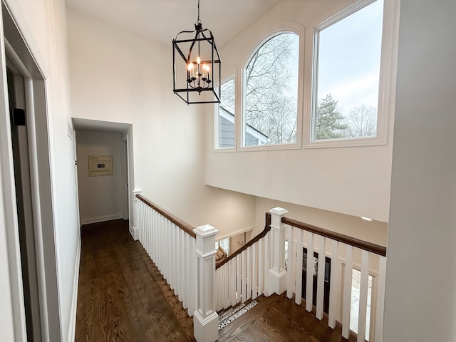 staircase with an inviting chandelier and wood finished floors