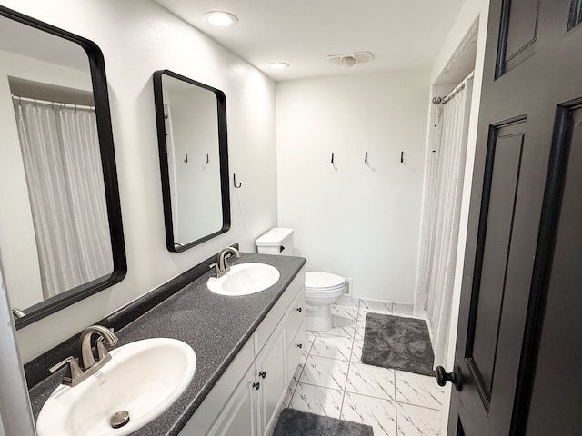 full bathroom featuring double vanity, toilet, marble finish floor, and a sink