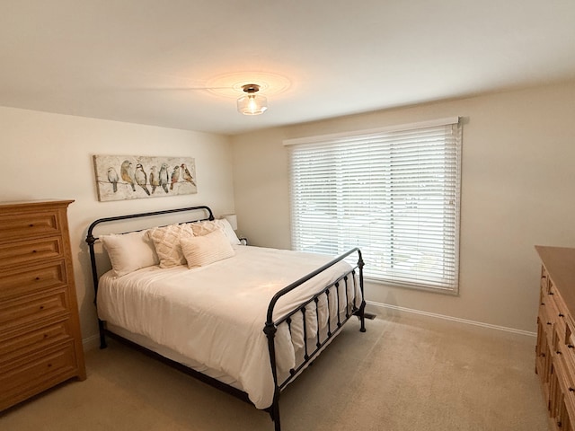 bedroom featuring baseboards and light carpet