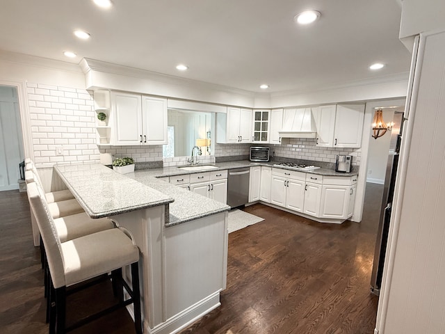 kitchen featuring white gas stovetop, dishwasher, a breakfast bar, custom range hood, and a peninsula