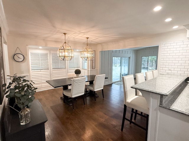 dining room with a notable chandelier, recessed lighting, dark wood-style flooring, and ornamental molding