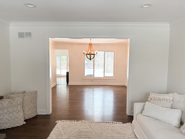 living room featuring visible vents, baseboards, dark wood finished floors, ornamental molding, and an inviting chandelier