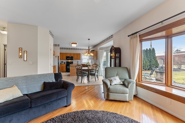 living area featuring plenty of natural light, baseboards, and light wood-style flooring