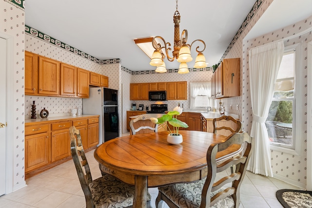 dining area featuring light tile patterned floors, a notable chandelier, baseboards, and wallpapered walls