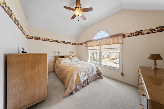 bedroom featuring light colored carpet, vaulted ceiling, baseboards, and ceiling fan