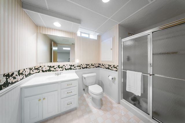 full bathroom featuring toilet, a wainscoted wall, vanity, a stall shower, and wallpapered walls