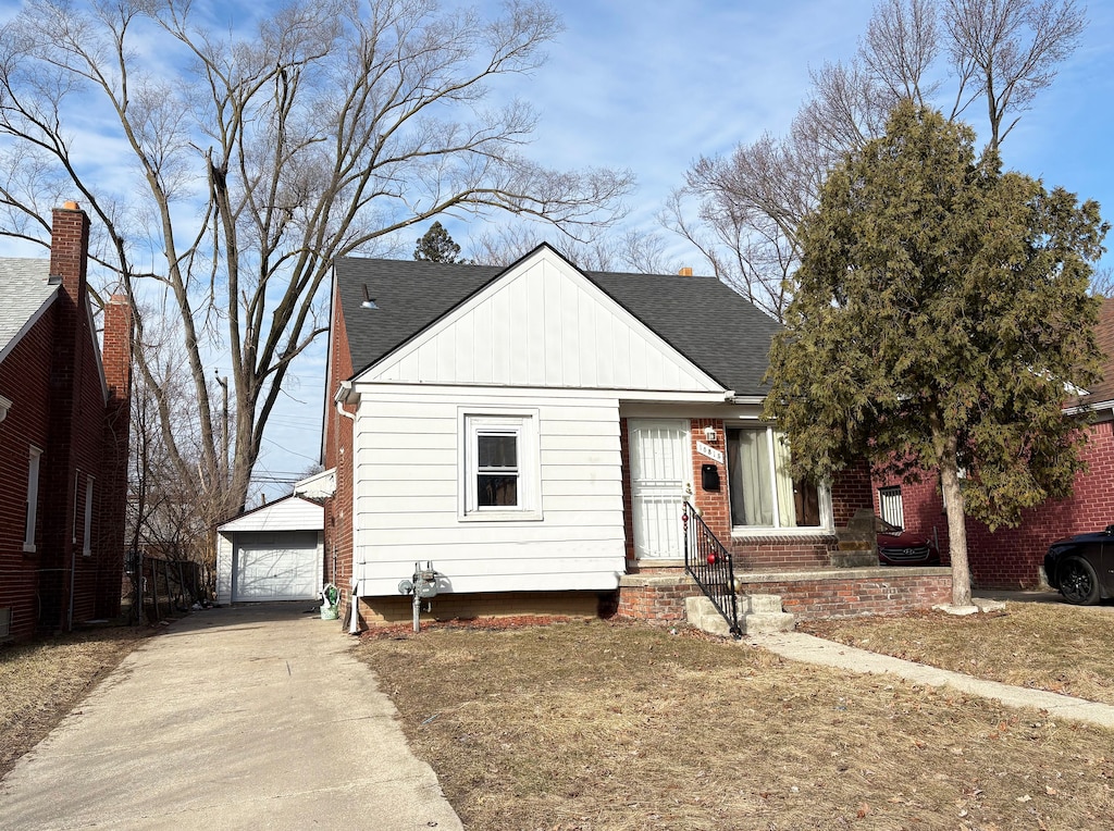 view of front of home with an outbuilding, a shingled roof, and a garage