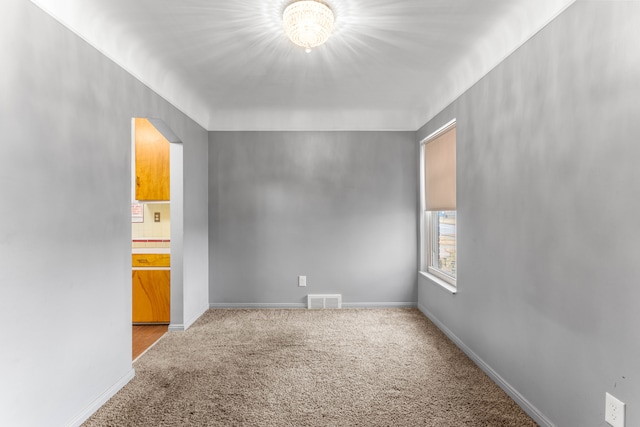 unfurnished room featuring visible vents, light carpet, and baseboards