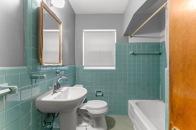 full bath with tile patterned flooring, wainscoting, tile walls, and toilet